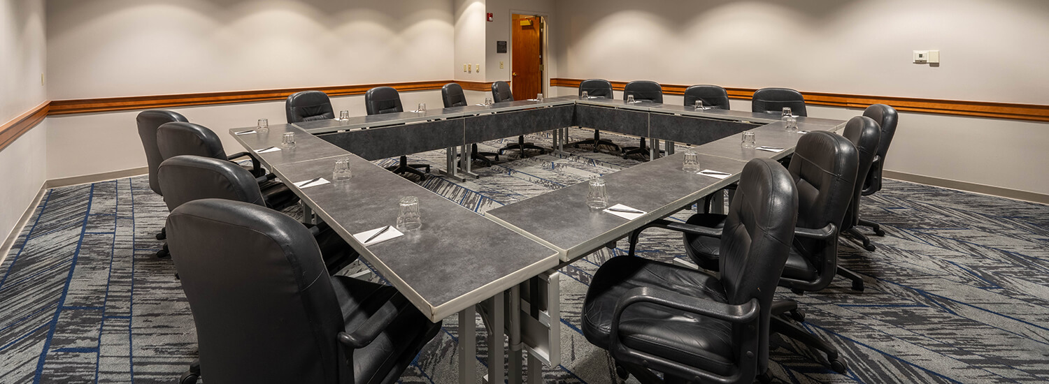 Small meeting room with square table and 4 chairs on each side